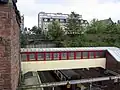 View down from the new road bridge showing the footbridge, with an eastbound train