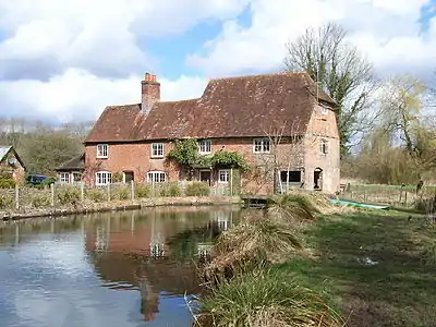 Greywell Mill on the upper reaches of the River Whitewater. The old waterwheel is still to be seen at the right-hand end of the building. (Photo by Andrew Smith, 2006)