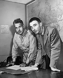 two men, one in military uniform and another in a suit, having a discussion