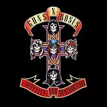 skulls resembling the members of Guns N’ Roses on an ornate cross on a black background, with the band name and album title written sideways on the left and right, respectively.