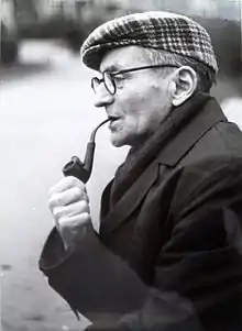 An old man smoking a pipe, looking to the left