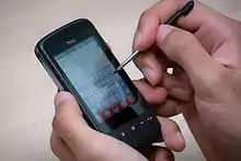 A smartphone being operated with a stylus