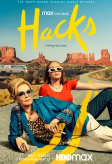 The poster shows Deborah Vance and Ava Daniel lying on their sides in the middle of the road in a desert landscape. They are staring directly into the camera, and the yellow paint of the road runs over their bodies. Deborah holds a microphone.