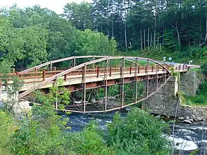 View of the bridge from the north, crossing a deep gorge, with curving trusses over and under