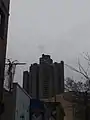 Both Towers are tall enough that they extend past the Victorian-Era Apartment buildings in the area.  Taken from Villa Avenue.