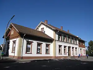 Two-story building with gabled roof and one-story wings