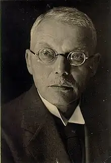 Black-and-white photograph of a middle-aged man, wearing spectacles.