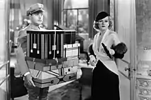 Albert carries an armful of boxes for Lillian