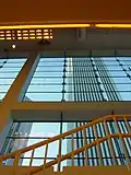 an upward view of a skyscraper from inside a building that faces it.