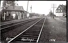 A postcard showing a small wooden train station in a rural area