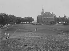 Black and white photograph of a baseball field with Healy Hall in the background