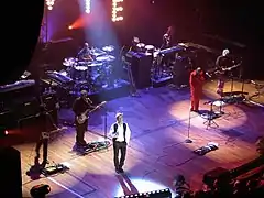 David Bowie on stage during his Heathen Tour in 2002; a portion of the lights' "W","I" and "E" are visible at the top of the picture