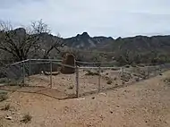 The fenced-in ruins of an adobe hotel in Helvetia.