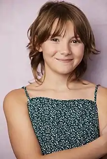 Hendrix Yancey smiling against a pinkish background in a floral top