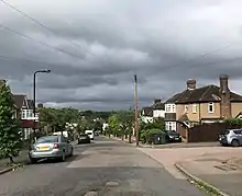 View down Henrys Avenue showing the architecture typical of the Highams Estate, and its proximity to the City of London, visible on the horizon.