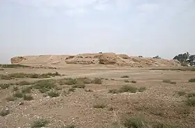 Photo of a mound of ruins in a barren field