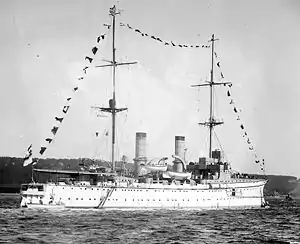 Black-and-white photograph of white ship with tall masts.