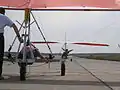 Complex control: The kited hang glider pilot is the main decision maker; the ultralight tug pilot has control duties. Hang glider on a runway, ready to start by UL-tow. The kite hang glider is sitting in a three-wheeled trolley while the trike is starting its engine.