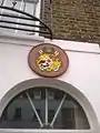 Plaque above the entrance depicting the Coat of arms of Tonga