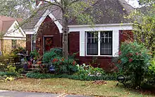 Small, one-story brick-faced house with small yard in front