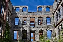 A view from the inside of the ruins of St. Agnes Hospital, showing stone walls and steel beams