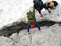 Alpinists over the randkluft of the Höllentalferner glacier