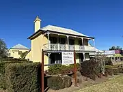 A 19th century two story builing, yellow, with balconies