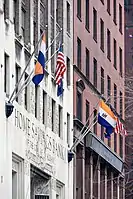 The building flies the flags of the United States, New York State, and the City of Albany.