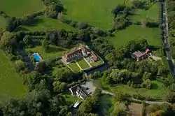 White house with red roof surrounded by green trees