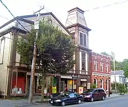 A tall building with peaked roof and a smaller brick one next to it