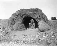 Image 6An Eastern Arrernte man of the Arltunga district, Northern Territory, in 1923. His hut is decked with porcupine grass. (from Aboriginal Australians)