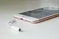 Headphone jack adapter with an iPhone 7 Plus beside it