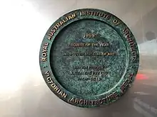 A cast bronze plaque architecture award fixed to a wall at the museum