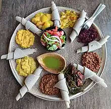 Typical Ethiopian and Eritrean cuisine: Injera (thin pancake-like bread) and several kinds of wat (stew)