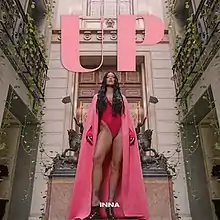 Cover of Inna's single showing the singer wearing a pink outfit while standing in a courtyard