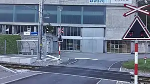 Small platform with shelter next to level crossing