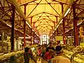 Meats, delicatessens, and other prepared food stands are inside the market.