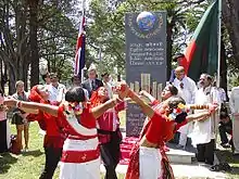 Outdoor ceremony, with girls in red-and-white costumes dancing