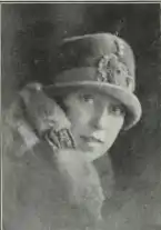 A young white woman wearing a felt hat low on her brow, and a fur collar.