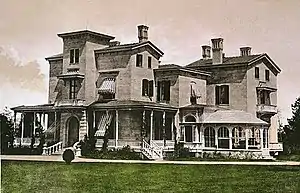 An older, hand-tinted postcard showing the house from a different angle