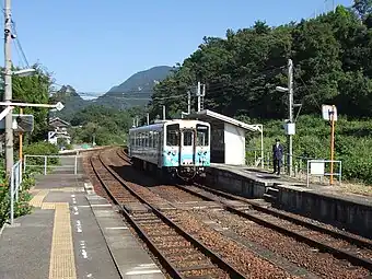 A view of the platforms looking in the direction of Matsuyama. The branch siding can be seen to the left. The level crossing with steps is just in front of the train.