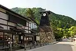 Wooden houses and a wooden clock tower on a stone base.