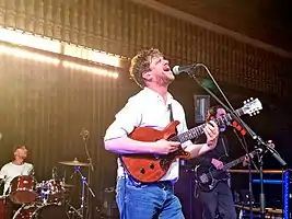 Jamie T playing guitar in concert