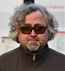 Jan Hřebejk facing the camera, wearing a black jacket and sunglasses