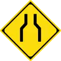 Road narrows on both sides