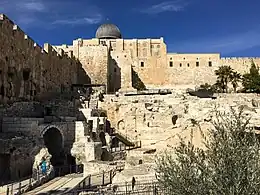 Excavated ruins of early Islamic palatial and administrative structures beneath the walls of a silver-domed mosque