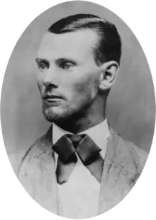 Oval-shaped black-and-white portrait photograph of a man with short slicked-back hair