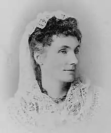 Black and white image of dark-haired woman with white veil over the back of her head