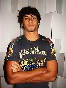 Jesus Luz staring towards the camera, in a colorful t-shirt.