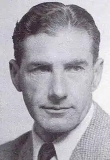 A headshot of a man looking away from the camera